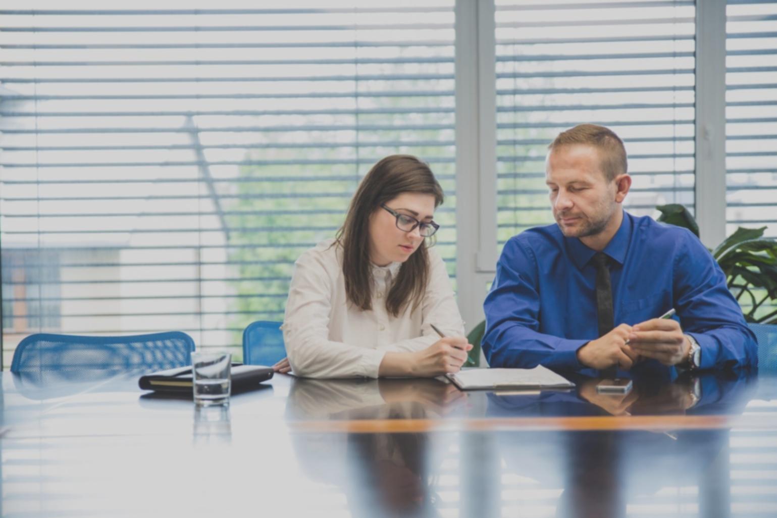 Bureau avec documents financiers et ordinateur portable montrant des tableaux de suivi budgétaire
